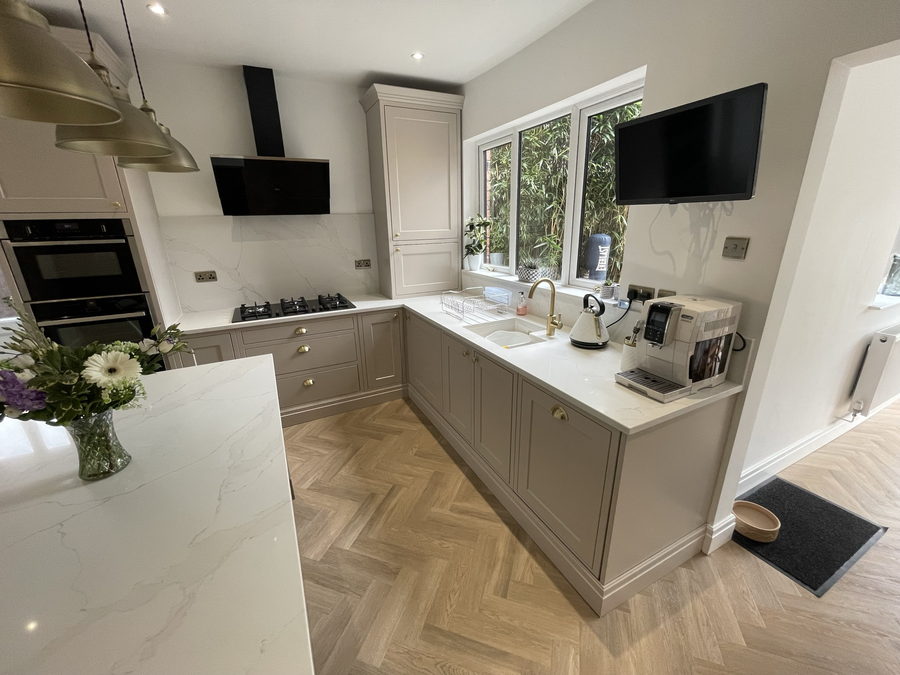 The finished room: taupe in-frame doors, a quartz island and a parquet floor
