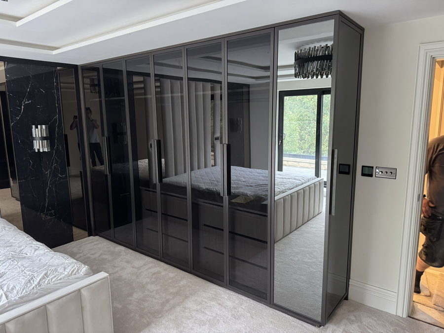Mirrored and marble-effect doors along the length of the bedroom