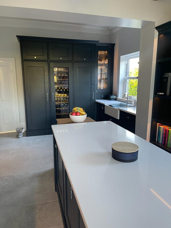 Navy in-frame cabinetry with a quartz island and a glazed dresser