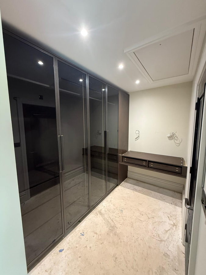 Dark-framed bronze glass wardrobe doors in the dressing room