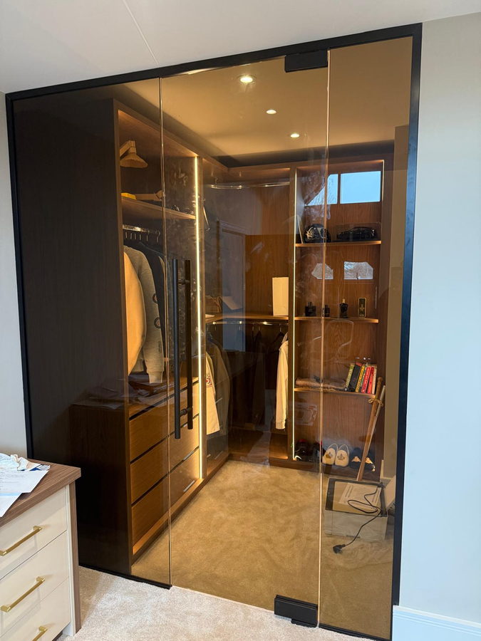 Bronze glass door opening to the LED-lit dressing room
